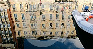 Boats moored on waterway and antique building reflected on water