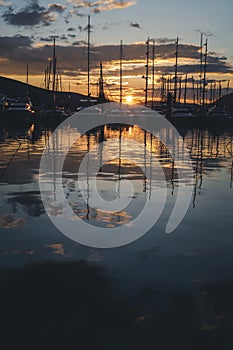 Boats, motorboats and yachts with masts in the port at sunset, beautiful seascape, marine travel and adventures