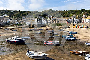 Boats in Mousehole harbour Cornwall England at low tide