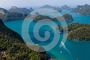 Boats navigate the serene blue waters among lush green islands under a clear sky. Koh Samui Island, Thailand photo