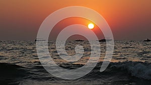 Boats in open sea on the calm waves against beautiful sunset, close to equator, tropical