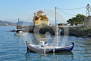 Boats with an Orthodox church in the background in the port of Gythio