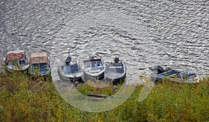 Boats with outboard motors on  traditional unguarded parking lot on river in Siberia
