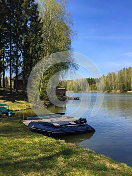 Beautiful lake landscape. A boats parked next to wooden pier on country lake.