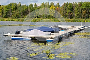 The boats are parked at the pier. Boat pier on the river in Russia