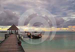 Boats on pier in the ocean at sunset