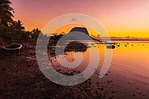 Boats and a quiet ocean at bright sunset time. Le Morn mountain in Mauritius