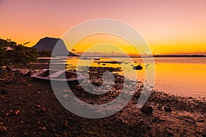 Boats and quiet ocean at sunset time. Le Morn mountain in Mauritius