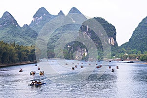 Boats and rafts on Li-River or Li Jiang, China with bizarre limestone mountains