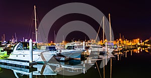 Boats reflecting in the water at night, in a marina on Kent Island