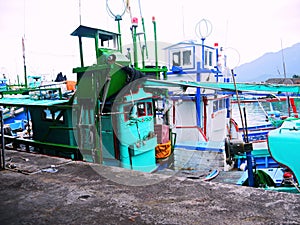 Boats resting in the harbour, bright hulls, adding color to the fishing port