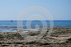 Boats sail on the Mediterranean Sea near the coast of Pefkos or Pefki, Rhodes island, Greece