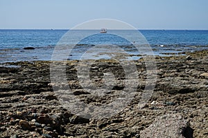 Boats sail on the Mediterranean Sea near the coast of Pefkos or Pefki, Rhodes island, Greece