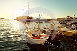 Boats and a sailboat moored in the harbor of a small town Postira - Croatia, island Brac