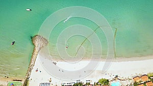 Boats sailing in sea and sandy beach in resort hotel drone view. Aerial view swimming pool in luxury resort hotel on sea