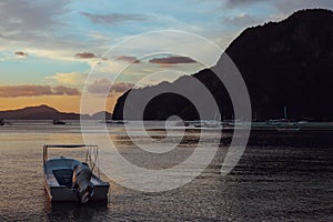 Boats in the sea at sunset. White boat on big mountain background.  Philippines isles. Fishing boat at sunset.