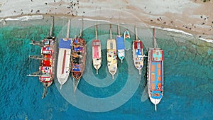 Boats in the sea, top view. Aerial view of colorful boats standing abreast on the shores of the Mediterranean sea in azure water.