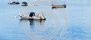 Boats and ships moored in a small port, in the background coastal town, fishing industry and tourism