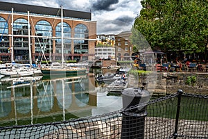 Boats And Ships In St Katharine Docks With Office Buildings And Restaurants In London, UK