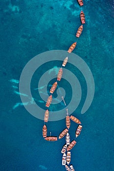 Boats view from sky on Braies Lake in Dolomites mountains