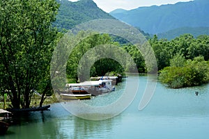 Boats are waiting for its passangers on the river in Virpazar