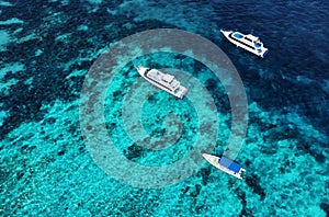 Boats on the water surface from top view. Azure water background from drone. Summer seascape from air.