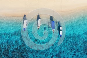 Boats on the water surface from top view. Turquoise water background from top view. Summer seascape from air. Gili Meno island, In