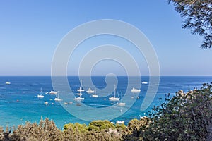 Boats and yachts anchored close to the sea shore in blue lagoon