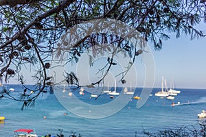 Boats and yachts anchored close to the sea shore in blue lagoon