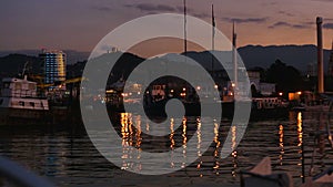 Boats and yachts docked in night Batumi port, harbor cityscape, Georgia tourism