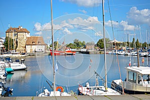 Boats, yachts and fishing vessels line the old harbor or Vieux Bassin in the charming Normandy village of Honfleur, France