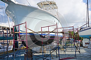Boatyard repair big boat on racks surrounded with work scaffolding photo