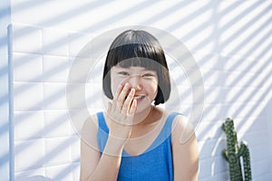 Bob haircut girl covering mouth and laughing