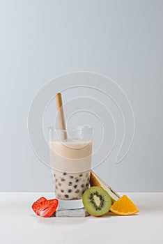 Boba tea/ bubble tea glass with fruit slices isolated on blue background