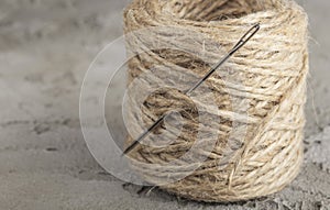 Bobbin, sewing needle and thick jute thread close-up