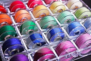 Bobbins with colorful threads in storage box