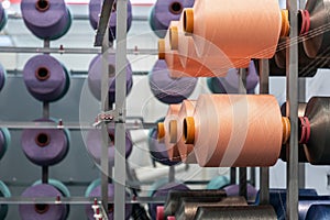 bobbins with threads of different colors on the shelves of a clothing factory