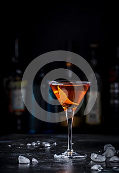 Bobby Burns strong cocktail drink with scotch whiskey, vermouth and liquor in martini glass, dark bar counter background