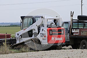 A Bobcat Skid steer loader at a work site with blue sky