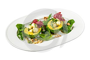 Bocconcini cheese balls in halves of avocado served with salad on white background