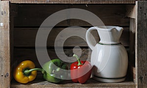 Bodegon with a pitcher and three peppers photo