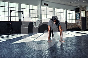 The body achieves what the mind believes. a young man doing push ups in a gym.