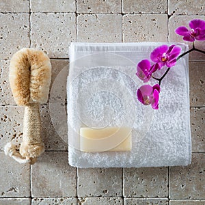 Body care with loofah brush, glycerin soap, white cotton towel photo