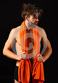 Body care. Man with orange towel on neck ready to take shower. Macho attractive nude guy black background. Man bearded