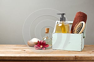 Body care products on wooden table over gray retro background