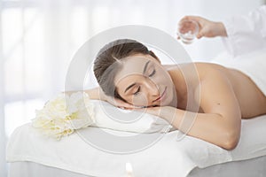 Body Care. Relaxed Beautiful Woman Getting Oil Massage In Luxury Spa Salon
