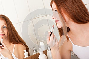 Body care - Young woman apply lipstick