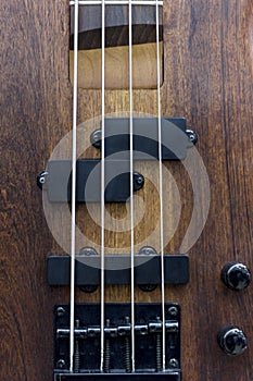 Body of a classic bass guitar. Electric bass guitar element. Guitar neck closeup. Chord. Selective focus.