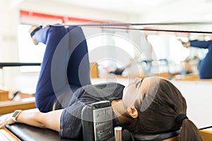 Body Conscious Woman Exercising On Pilates Reformer Machine