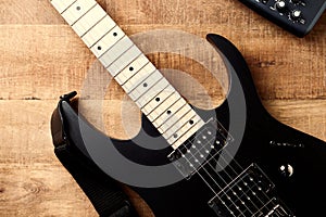 Body and fretboard of modern electric guitar on rustic wooden background.